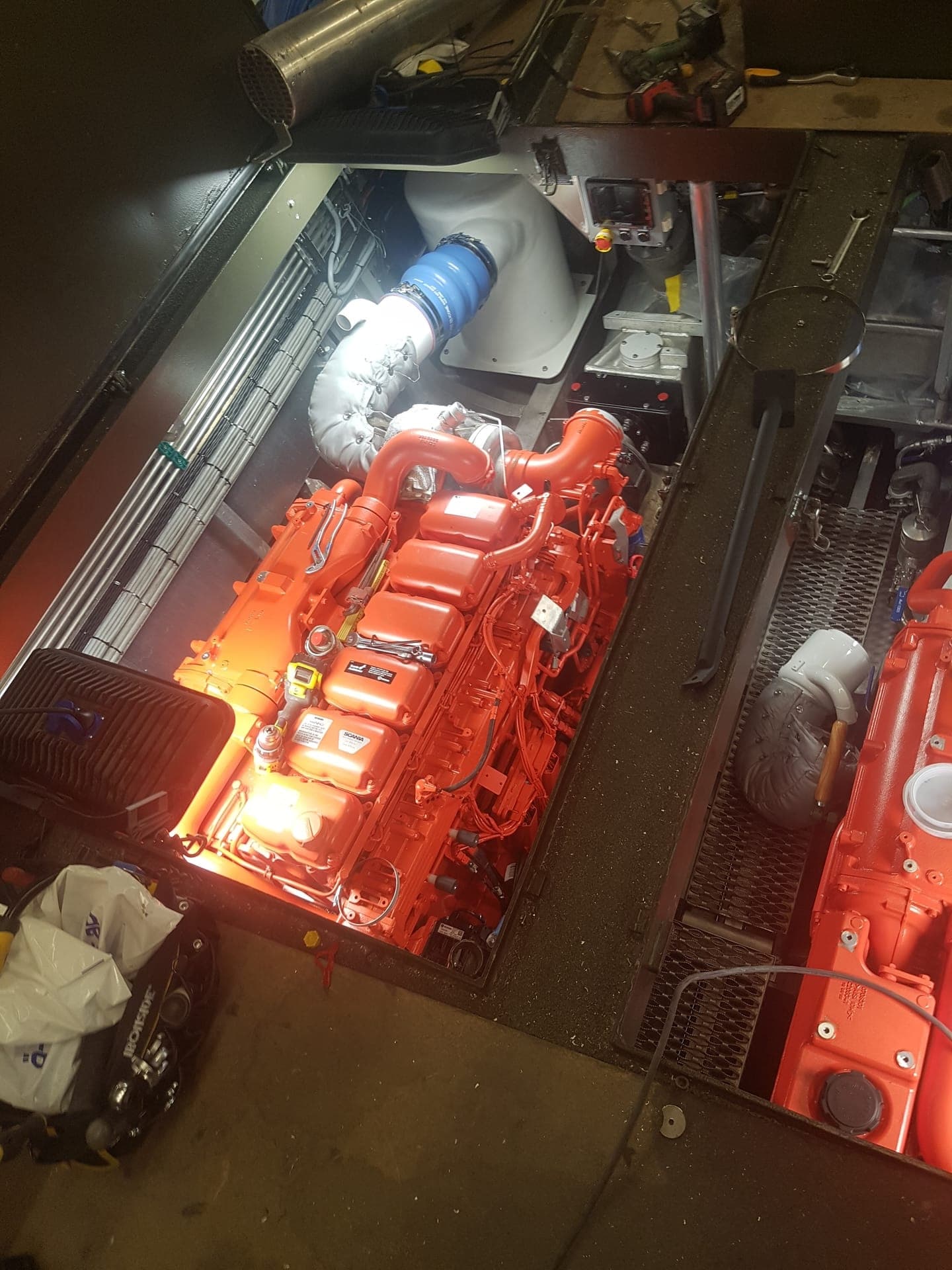 Nymålad orange/röd dieselmotor på plats under installation i maskinrum